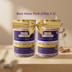 Two jars of Nut Story Daily Wellness Trail Mix with a gold bow on a wooden surface.